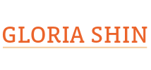 A geometric orange emblem made of nested rectangles and diagonal lines sits to the left of the name ‘GLORIA SHIN’ in uppercase orange text with a thin horizontal line beneath it.
